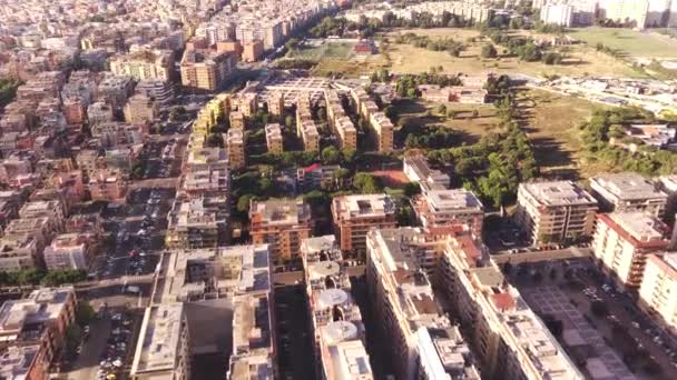 Vue aérienne des oiseaux du bloc de construction de la ville situé dans la ville métropolitaine vol sur les toits et les rues avec des véhicules circulant filmés par drone se déplaçant lentement montrant plus d'hommes de l'environnement urbain — Video