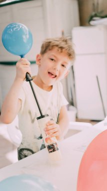 Roma İtalya. Haziran-21 arası. 2020. Bahçedeki çocuğun doğum günü. Ebeveynler hediyeleri açmaya yardım eder. Mutlu yıllar, mutlu yıllar. Mutlu oğul mavi top üflüyor..