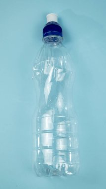Plastik içecek şişesi mavi arka planda izole edilmiş..