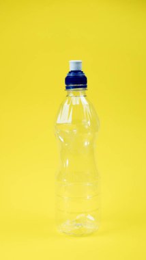 Plastik içecek şişesi sarı arka planda izole edilmiş..