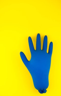 Sarı arka planda şişmiş mavi eldivenler. Konsept 2020 'de patlak veren bir salgın..