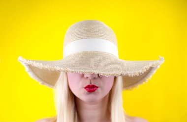 Kırmızı dudaklı ve şapkalı kız, yakın plan, sarı arka plan..