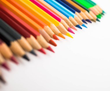 Beyaz arka planda izole edilmiş renkli boya kalemlerinin yakın çekimi.