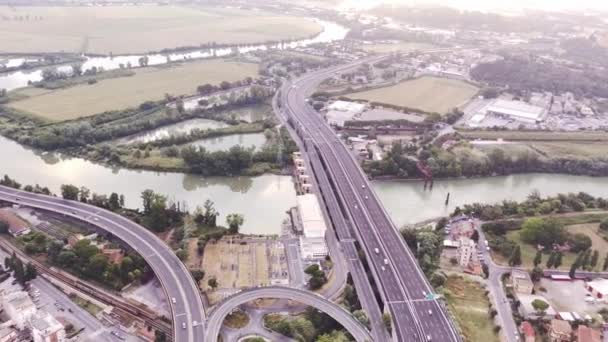 Widok z lotu ptaka na autostradę przez zielone pola w letni słoneczny dzień. Nagranie 4k krajobrazu z asfaltową autostradą pomiędzy łąkami. Drone nagrywa wideo — Wideo stockowe