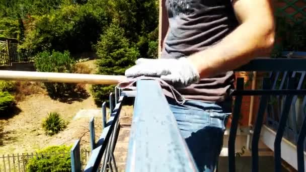 Robotnik używa papieru ściernego do czyszczenia poręczy z farby — Wideo stockowe