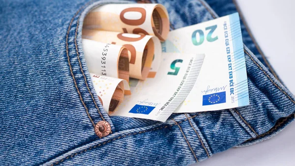 Billetes de banco en euros en un bolsillo trasero de un vaquero azul marino como composición de fondo —  Fotos de Stock