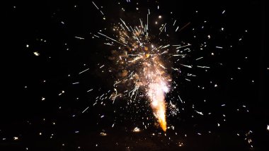 Turuncu, siyah gökyüzü arka planında bulanık havai fişek ışıkları. Yeni yıl ve Noel kavramı.
