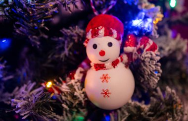 Karanlık bir odada parıldayan bir çelengi olan klasik Noel ağacı. Noel arkaplanı.