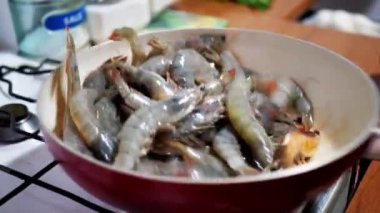 Karışık büyük kırmızı karidesler tavada kaynamış yağda kızartılıyor, yakın plan.