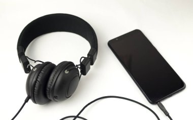 Kulaklık ve akıllı telefon beyaz arkaplanda izole edildi.