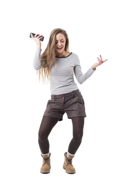 ハッピーは ダンス 携帯電話スピーカーで音楽を聴く若い女性を興奮させた 全身白い背景に分離 — ストック写真