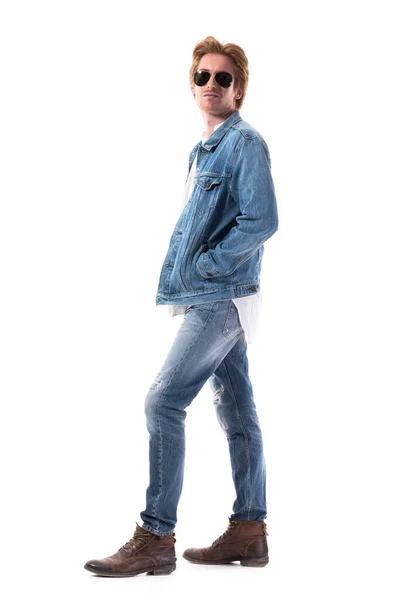 デニムジャケットジーンズや革のブーツで若いジンジャーマシン男性ファッションモデルのサイドビュー 白い背景に隔離された全身の長さ — ストック写真