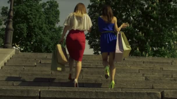Kadınlar alışveriş torbaları şehirde yukarı gidiş ile — Stok video