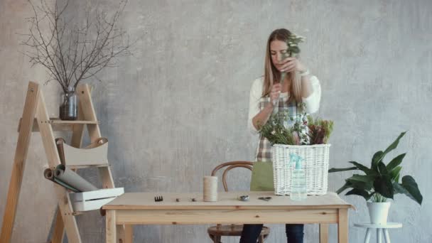 Флорист возлагает цветы и растения на рабочем месте — стоковое видео