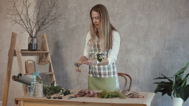 Skillful florist cuts ends of flowers with pruner — Stock Video