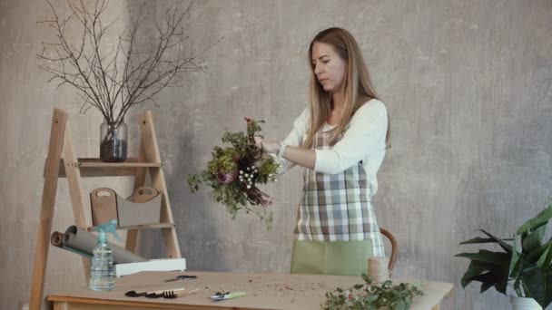 Charmanter Blumenhändler arrangiert Blumen im Blumenladen — Stockvideo