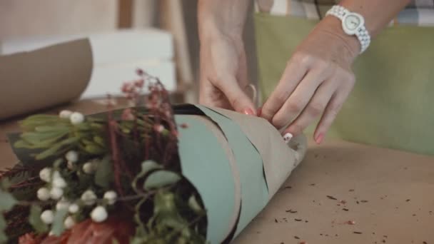 Florist verpackt festlichen Strauß in Packpapier — Stockvideo