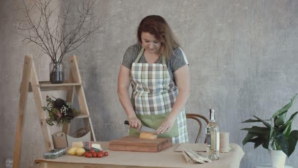 Belle femme coupant délicieux fromage à bord — Video