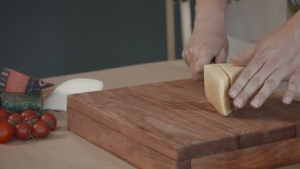 Weibliche Hände schneiden Käse auf Schneidebrett — Stockvideo