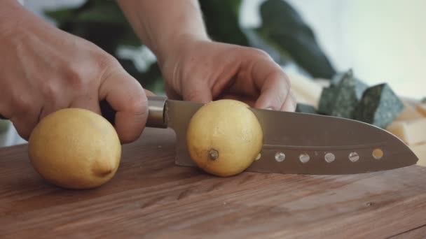 Mani femminili che tagliano limoni freschi sul tagliere — Video Stock