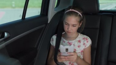 Küçük kız metin arabada akıllı telefon üzerinde haber