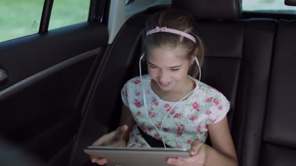 Child playing online game with tablet pc in car — Stock Video