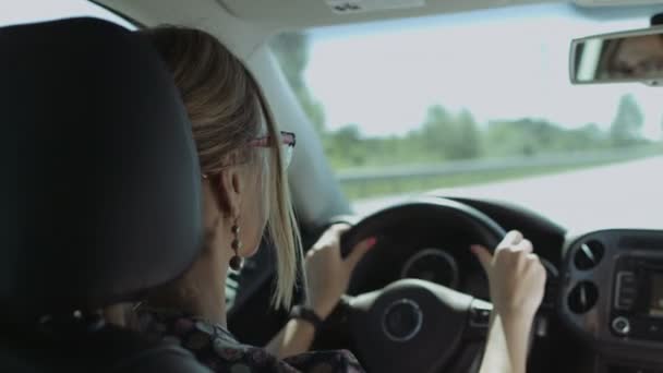 Mujer positiva conduciendo coche en la carretera interestatal — Vídeo de stock