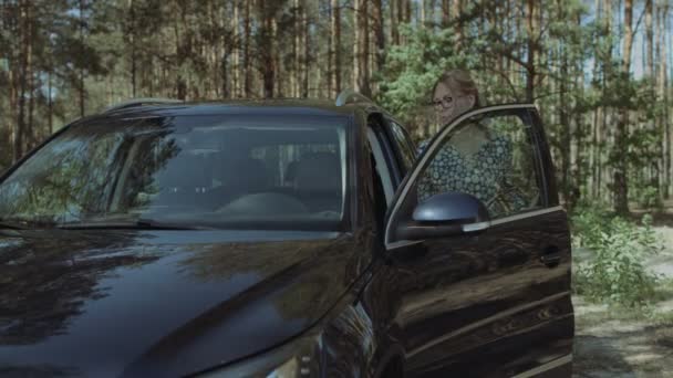 Mujer rubia encantadora entrar en el coche de lujo — Vídeos de Stock