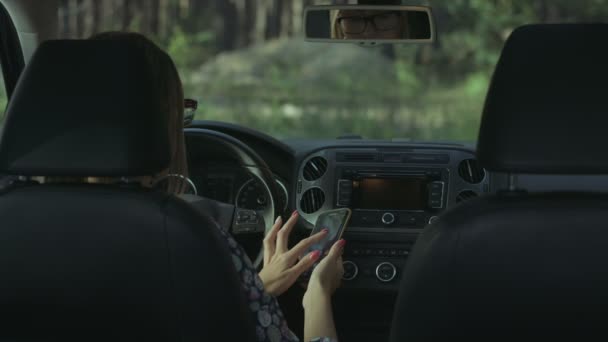 Chauffeur féminin utilisant un téléphone intelligent dans la voiture — Video