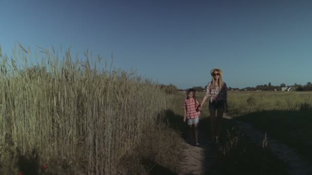 Mamá y el niño caminando por la carretera rural en el campo — Vídeo de stock