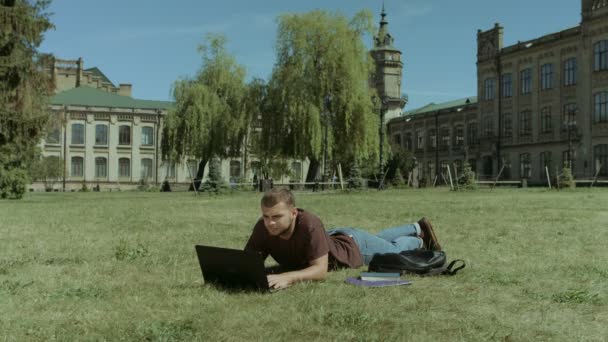 Studentów uczelni korzystających wypoczynek na trawniku campus — Wideo stockowe