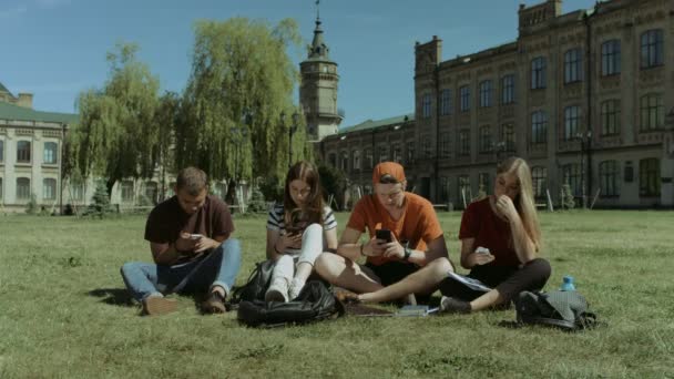 Studerende med mobiltelefoner ignorerer hinanden – Stock-video