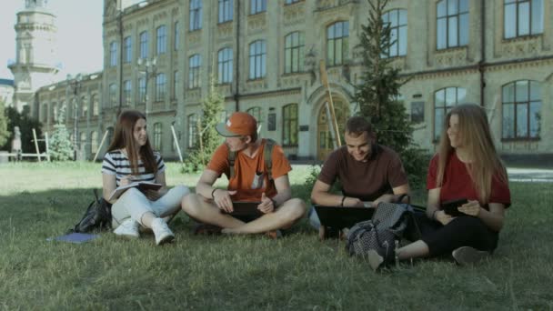 Groep studenten delen de ideeën over gazon van de campus — Stockvideo