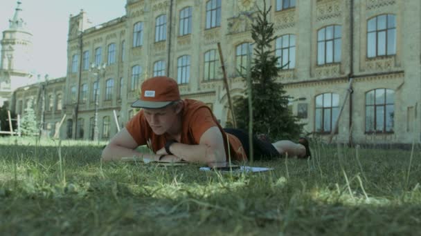 Konzentriertes studentisches Lernen auf dem Campus-Rasen — Stockvideo