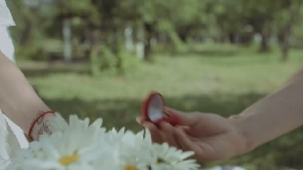 Hombre poniendo anillo de compromiso en la mano mujer al aire libre — Vídeos de Stock