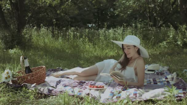 Mulher elegante lendo um livro no parque de verão — Vídeo de Stock