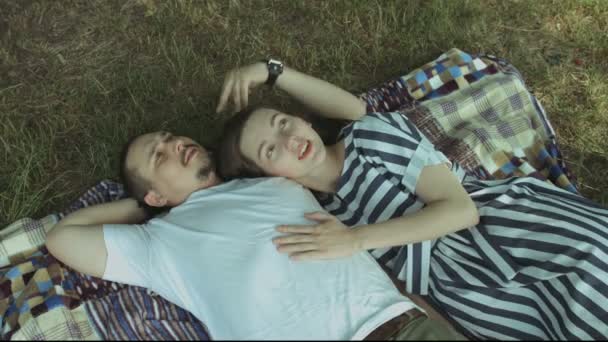 Loving couple lying on picnic blanket and relaxing — Stock Video