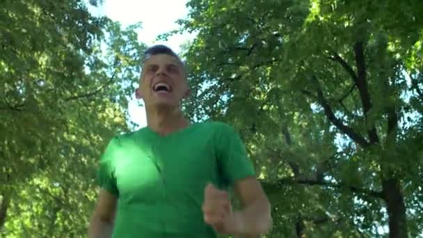 Hombre corredor escuchando música durante el entrenamiento de carrera . — Vídeos de Stock