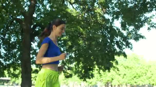 Bella donna fitness che fa jogging nel parco estivo — Video Stock