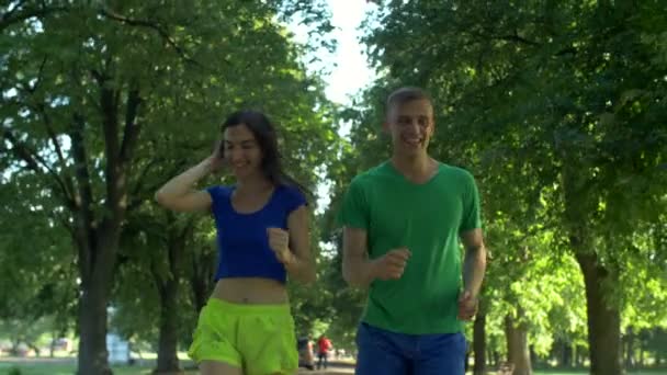 Active couple jogging together in summer park — Stock Video