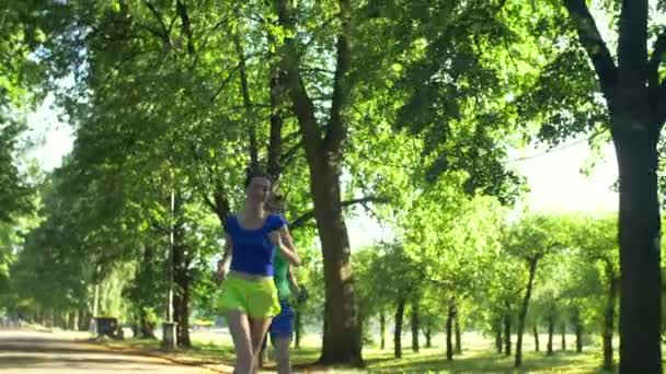 Positieve mannelijke atleet outrunning vrouwelijke jogger — Stockvideo