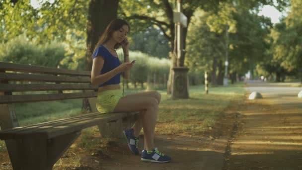 Jogging woman setting music on mp3 player before run — Stock Video