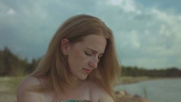 Portrait of pensive ginger woman resting at seaside — Stock Video