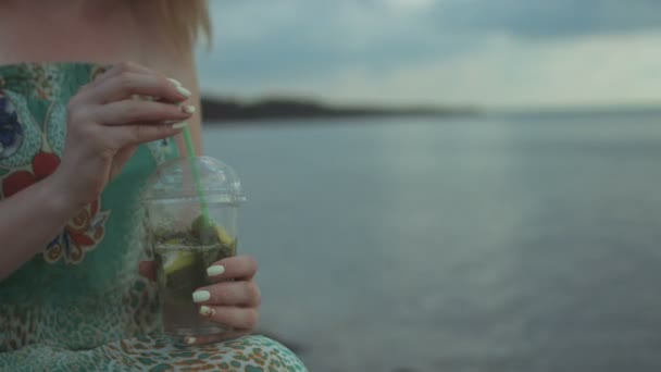 Mains féminines tenant un cocktail mojito sur la plage — Video