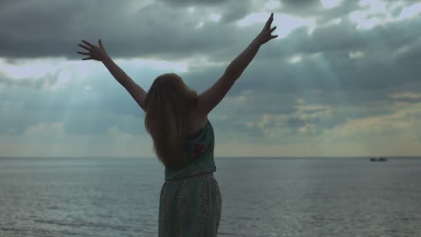Sahilde geniş açık kollar ile büyüleyici kadın — Stok video