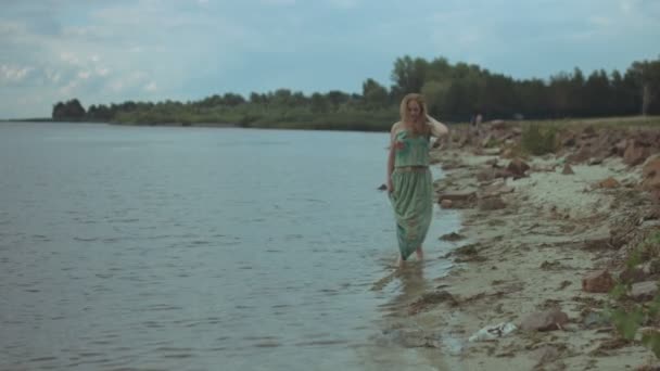 Femme souriante pieds nus marchant sur le bord de la mer — Video