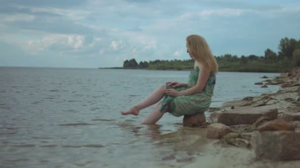 Привлекательная рыжая женщина брызгает водой в море — стоковое видео