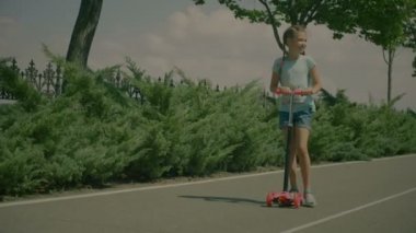 Mutlu küçük kız sürme tekme scooter Park