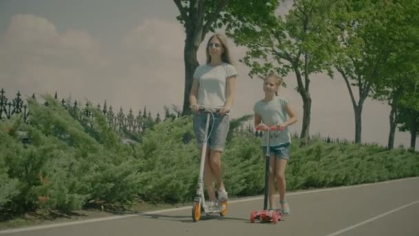 Moderne familie rijden scateboard scooters in de natuur — Stockvideo