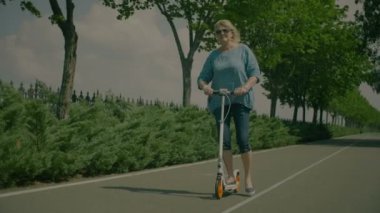 Pozitif aktif kadın kıdemli binme scooter Park